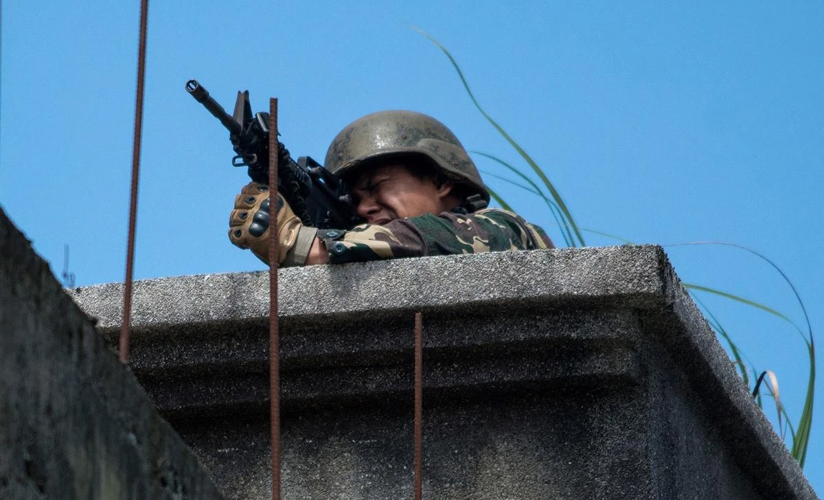 A Philippine soldier takes aim at militant positions from a building's rooftop in Marawi on the southern island of Mindanao. (AFP)