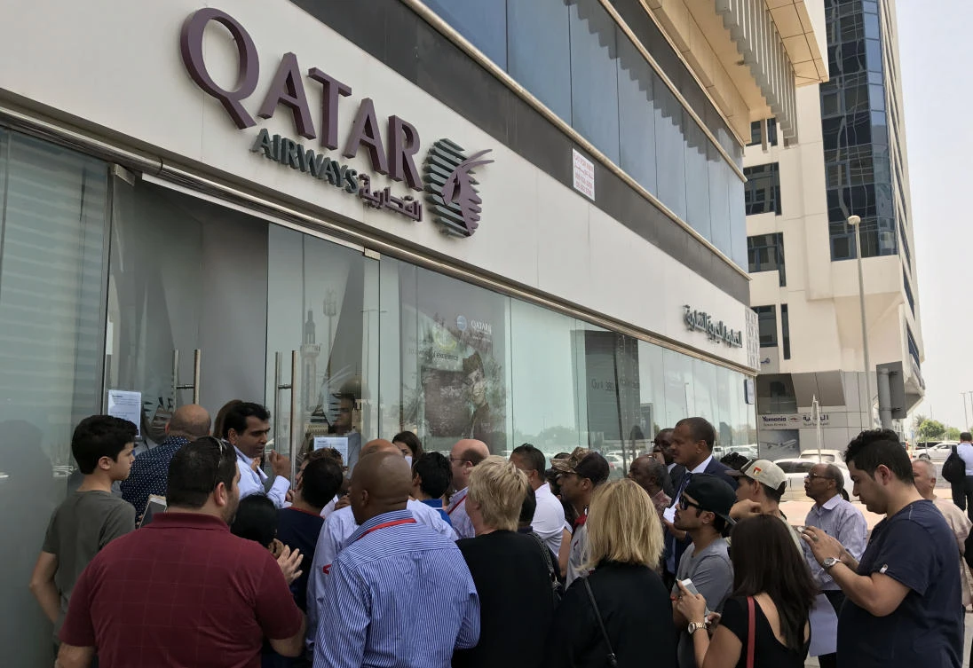 People gather outside a branch of Qatar Airways in the United Arab Emirate of Abu Dhabi. (AFP)