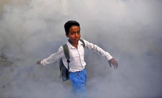 A schoolboy walks amid fumes emitted from fumigation work carried out by a municipal worker (unseen) in a residential locality in New Delhi, India, in this 2015 archive photo. (REUTERS/Anindito Mukherjee)