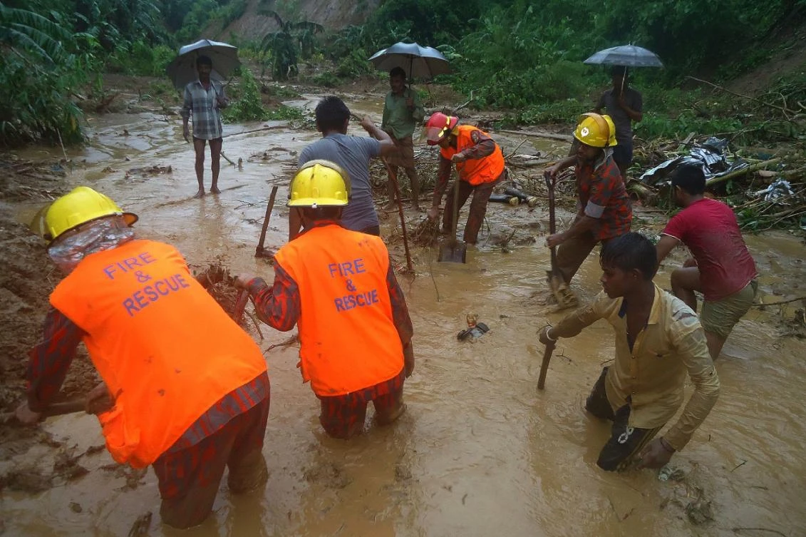 Bangladeshi fire fighters and residents search for bodies after a landslide in Bandarban. (AFP)