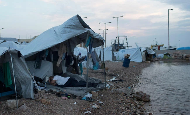 Refugees sleep outside a tent at a beach near the Souda refugee camp of Chios island, Greece, on June 9, 2017. The International Organization for Migration says more than 60,000 migrants have reached the shores of Europe so far in 2017, a sizable decrease compared to the same period last year. (AP Photo/Petros Giannakouris)