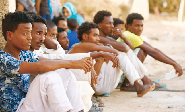 Eritrean migrants sit at the Wadi Sherifay camp on May 2, after being caught by Sudanese border security illegally crossing the Eritrea-Sudan border in the eastern Kassala state. (AFP)