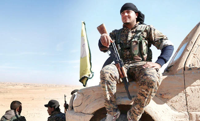 A Syrian Democratic Forces fighter rests with his weapon on a vehicle camouflaged in this file photo. (Reuters)