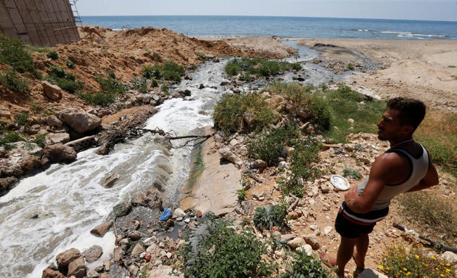 A man stands near a sewage outlet into the sea of Ramlet al Bayda public beach in Beirut, Lebanon, on June 6, 2017. A company contracted by the Lebanese government is also now dumping garbage into the sea off Beirut, sparking outrage among citizens. (REUTERS/Mohamed Azakir)