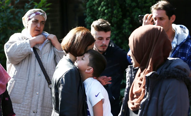 A woman comforts a boy after a tower block was severly damaged by a serious fire, in north Kensington, West London, Britain June 14, 2017. (Reuters)