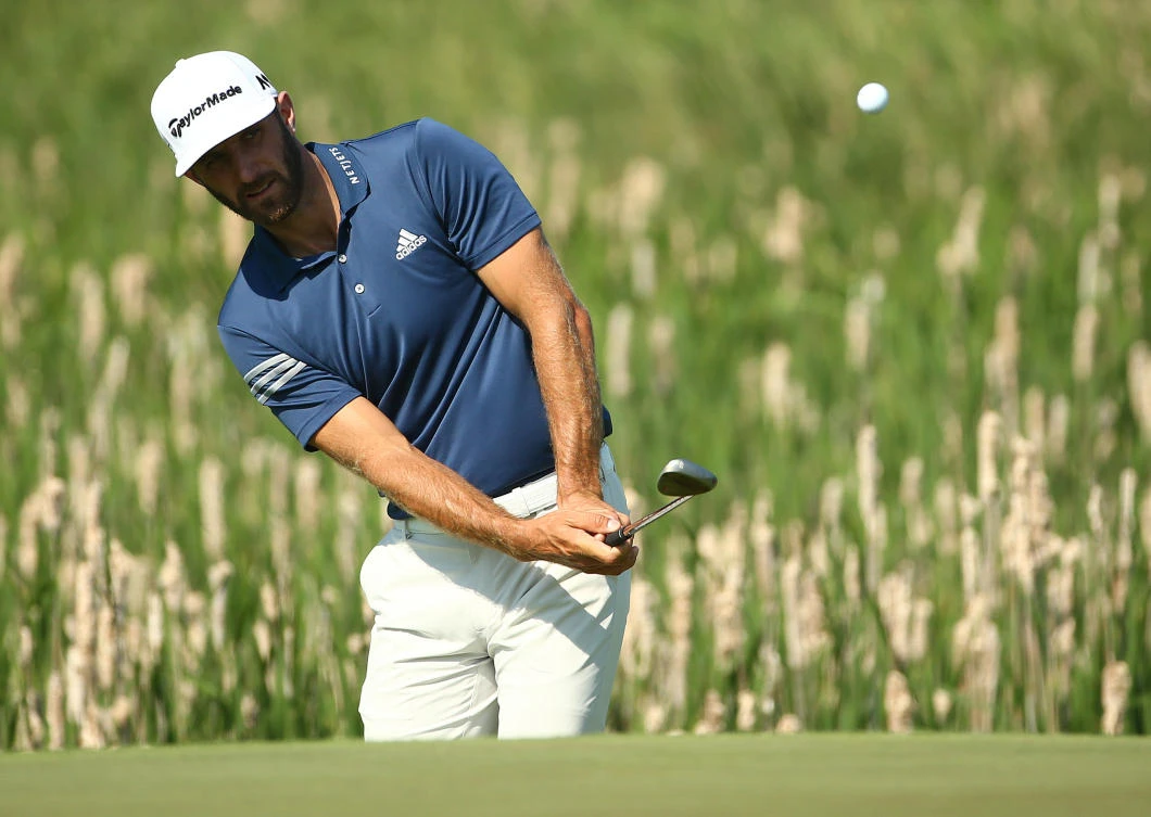 Defending champion Dustin Johnson chips up to the first green during a practice round of the US Open golf tournament at Erin Hills on Tuesday. -(USA TODAY Sports)