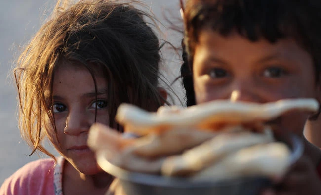 Displaced Iraqis receive aid food during the holy month of Ramadan at Al-Khazir camp for the internally displaced, located between Arbil and Mosul. (AFP)