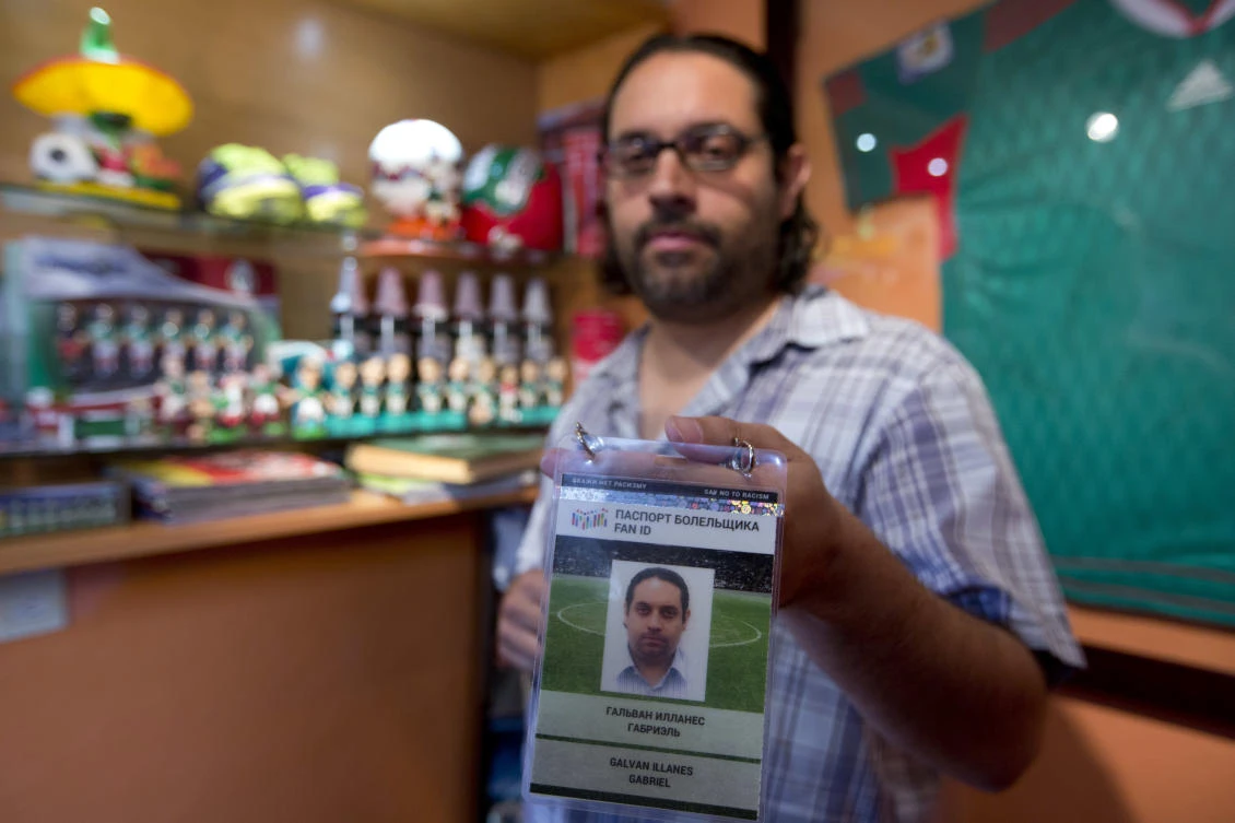 Gabriel Galvan, one of the founders of "La Ola Verde," or the Green Wave, poses with his accreditation for the Confederations Cup soccer game between Mexico and Russia, at his home in Mexico City. (AP)