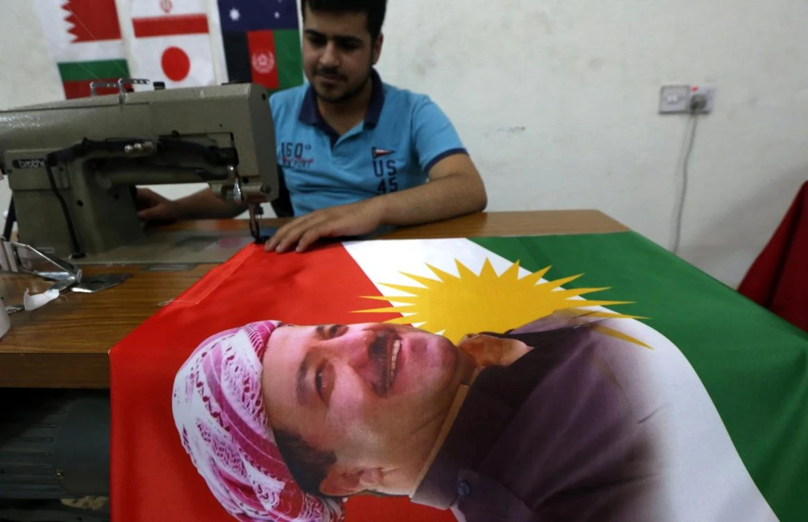 An Iraqi man sews a flag of Kurdistan bearing the portrait of Iraqi Kurdish leader Massud Barzani, in Arbil, the capital of the autonomous Kurdish region of northern Iraq, on June 8, 2017. Iraq's autonomous Kurdish region will hold a historic referendum on statehood in September, despite opposition to independence from Baghdad and possibly beyond. (AFP)