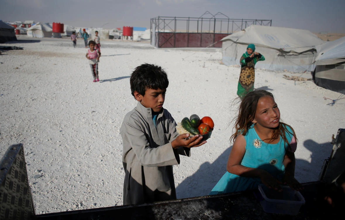 A boy holds a plate with food at a camp for people displaced from fighting in the Islamic State stronghold of Raqqa, in Ain Issa, Syria June 14, 2017. )REUTERS)