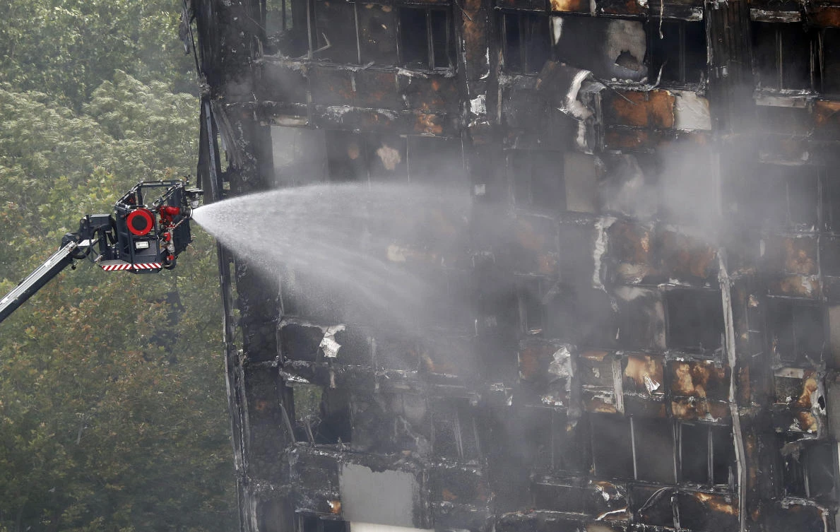 A remote firefighting platform continue to damp-down the deadly fire at Grenfell Tower in London.(AP Photo/Frank Augstein)