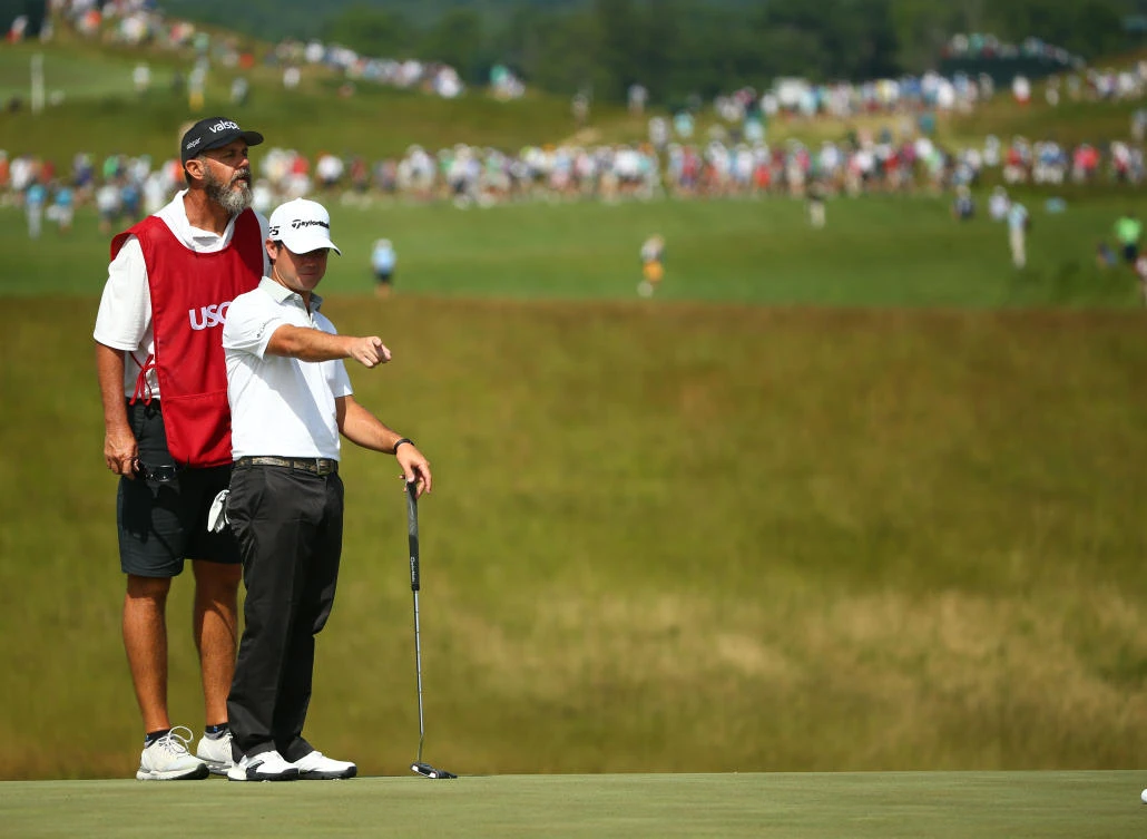 Brian Harman looks over his putt with his caddie Scott Tway on the 18th green during the first round of the US Open golf tournament at Erin Hills on Thursday. (USA TODAY Sports)