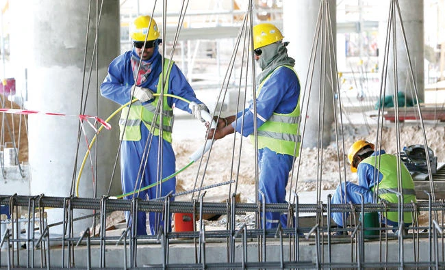Migrant laborers work at a construction site in Doha in this file photo. (AFP)