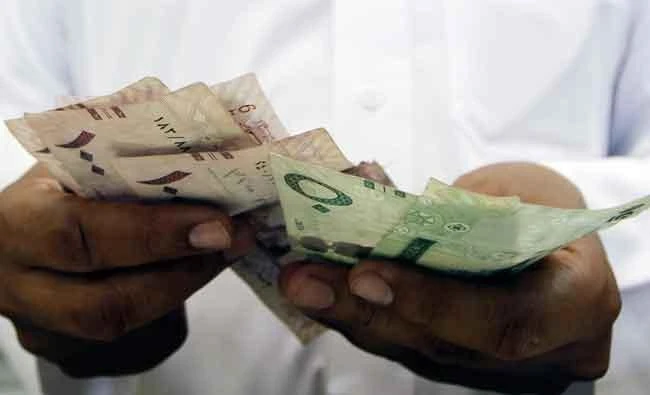 A Saudi Jeweller counts Saudi Riyal banknotes money after selling gold to a customer in a jewellery shop at the surrounding area of the Grand Mosque during the annual haj pilgrimage in the holy city of Makkaha in this October 20, 2012 file photo. (Reuters)
