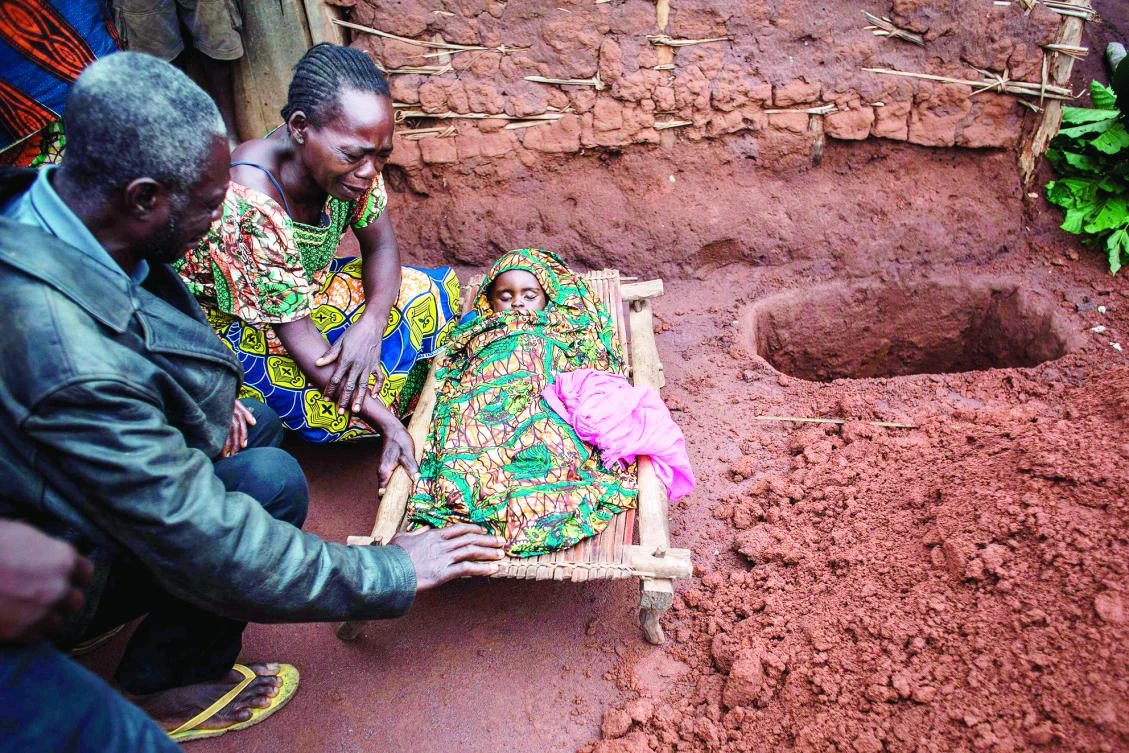 Relatives mourn the death of a baby after she passed away as an outbreak of malaria hit their village in Muma, DR Congo, on Tuesday. (AFP)