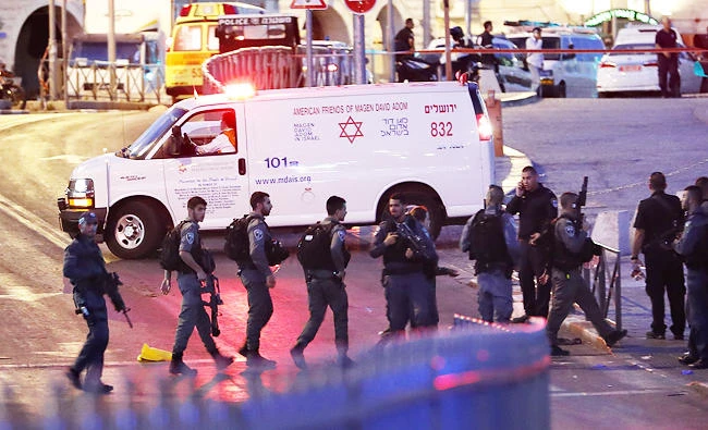 Israeli security forces and an ambulance are seen at the scene of an attack outside Damascus Gate in Jerusalem's Old City on Friday. (AFP)