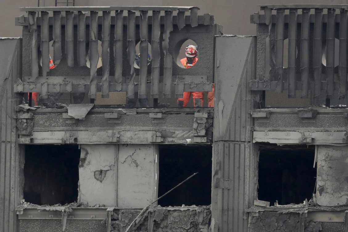Emergency workers stand on a roof section of the fire-gutted Grenfell Tower in London, Friday, June 16, 2017, after a fire engulfed the 24-storey building on Wednesday morning. (Photo: AP/Matt Dunham)