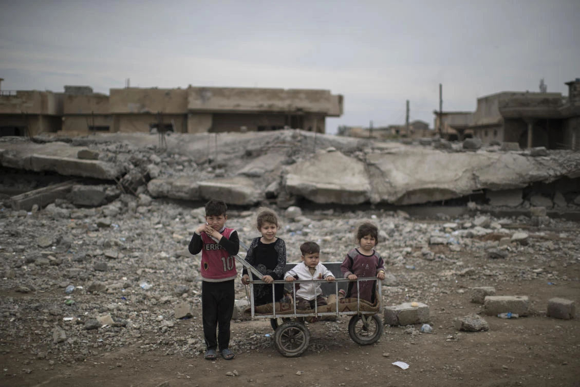 FILE- In this Friday, March 31, 2017 file photo, children wait as their mother collects food being distributed in a neighborhood recently retaken by Iraqi security forces during fighting against Islamic State militants on the western side of in Mosul, Iraq. Mosul's children are bearing the brunt of the intensified fight between U.S.-backed government forces and the Islamic State group in the city's western half, the United Nations children's agency warned on Monday, June 5, 2017. (AP)