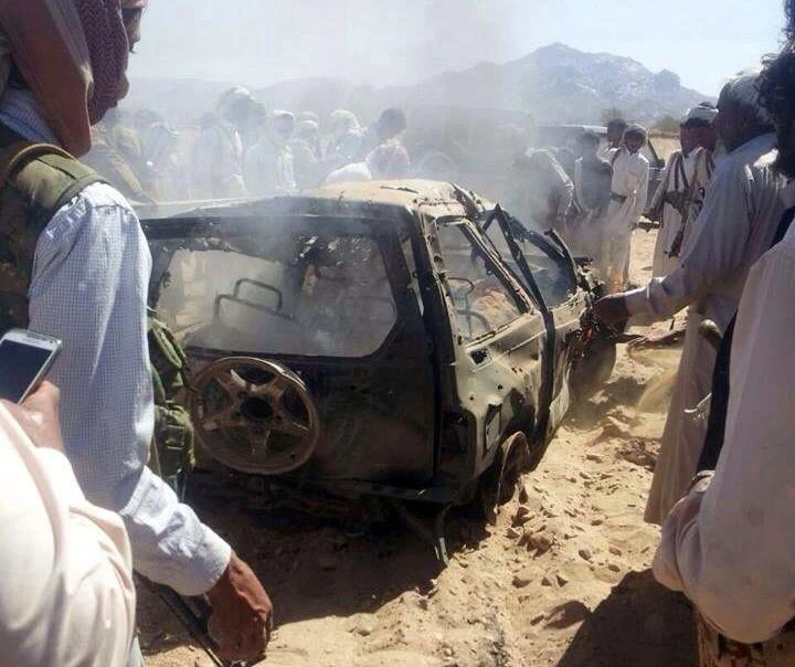 Yemenis gather around a burnt car after it was targeted by a drone strike killing three suspected al-Qaeda militants in January last year. (AFP)