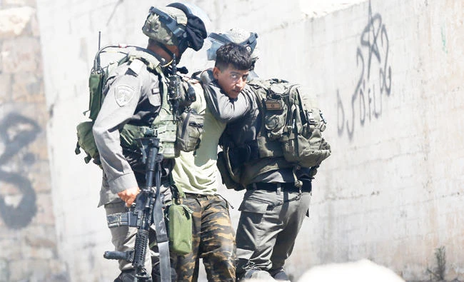 Israeli border police arrest a Palestinian during clashes in the West Bank village of Deir Abu Mash'al near Ramallah, on Saturday. (AP)