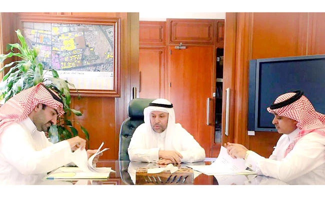 KAU President Abdulrahman Al-Youbi, center, witnesses the signature ceremony between PKAFM head Alhasan Almnakharah, left, and ELI Dean Abdullah Al-Bargi, right, at King Abdul Aziz University (KAU) in Jeddah.
