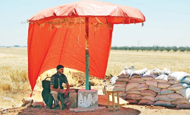A Free Syrian Army fighter sits in the shade at Al-Nuaimah village in Daraa province, Syria, Saturday. (Reuters)