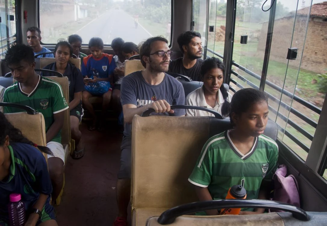 In this Thursday, June 8, 2017 photo, Franz Gastler, center, founder of Yuwa, a non-profit organization teaching girls soccer, sits inside a bus with students as they return after a morning practice session in Ormanjhi, Jharkhand state, India. For all of the girls, soccer — or football, as they call it — is an opportunity for them to overcome deeply entrenched discrimination in their rural villages. (AP)