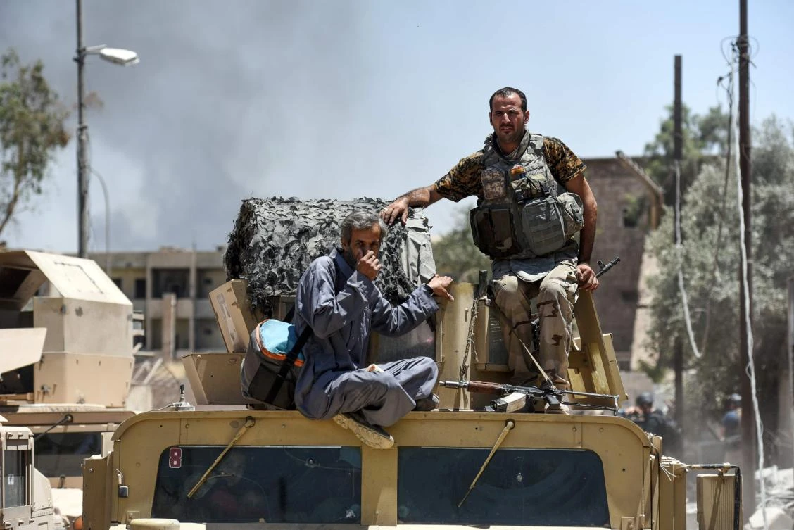 A displaced Iraqi man is escorted by Iraqi forces after fleeing his home in Mosul's western Al-Shifa district. (AFP)