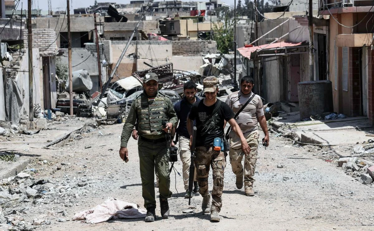 Members of the Iraqi forces walk down a street in Mosul's western Al-Shifa district. (AFP)