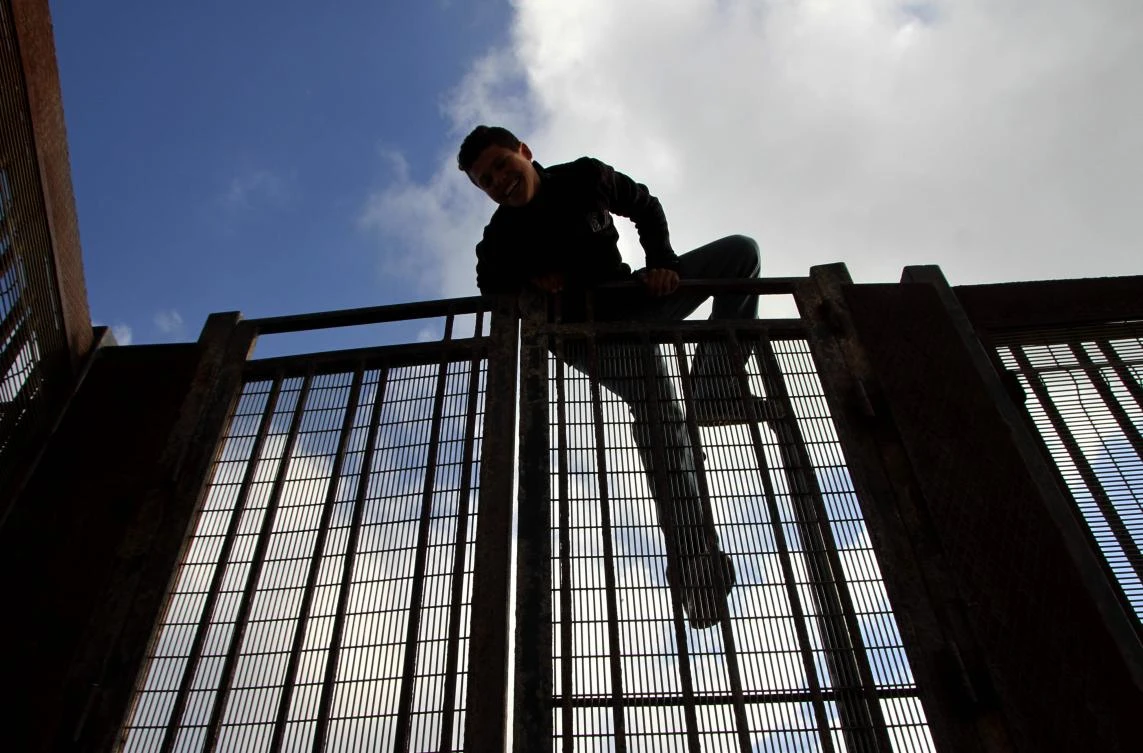 A Moroccan boy climbs a fence in the port of the Spanish enclave of Melilla bordering Morocco. (AFP)