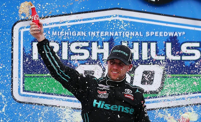 Denny Hamlin, driver of the #20 Hisense Toyota, celebrates in Victory Lane after winning the NASCAR XFINITY Series Irish Hills 250 at Michigan International Speedway on Saturday in Brooklyn, Michigan. (AFP)