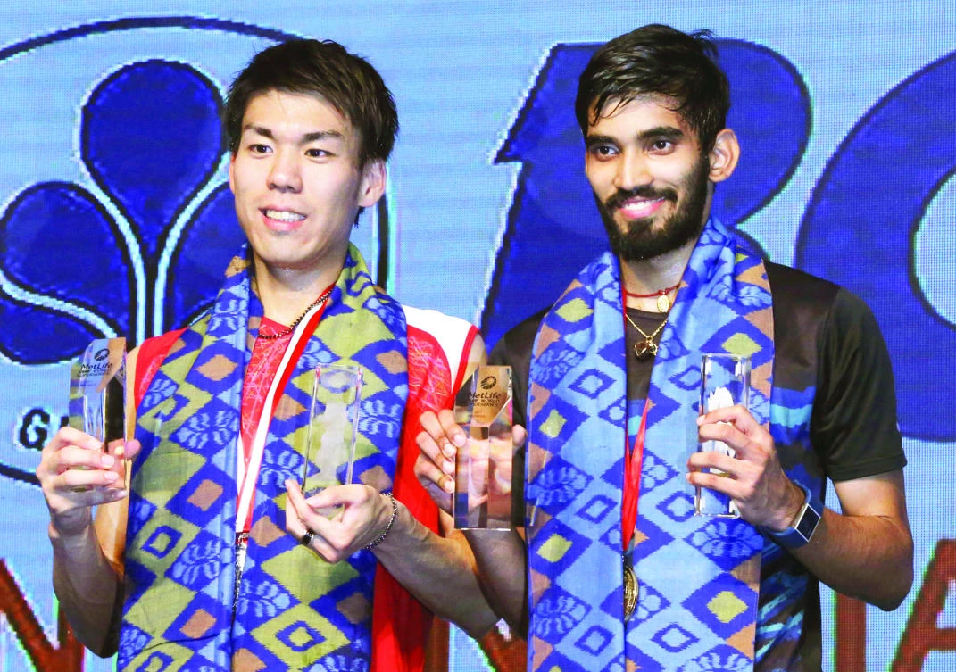 India's Srikanth Kidambi, right, and Japan's Kazumasa Sakai show their trophies after their men's singles final match at Indonesia Open badminton championship in Jakarta Sunday. Kidambi won the match 21-11, 21-19. (AP)