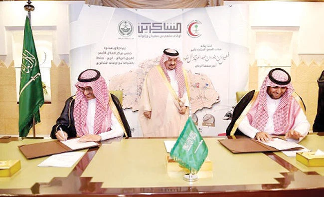Riyadh Gov. Prince Faisal bin Bandar, center, witnesses the signing ceremony between President of the Saudi Red Crescent Authority Mohammed bin Abdullah Al-Qassim, left, and Chairman of the Board of Trustees of the Shakreen Endowments Sheikh Malhi bin Salama bin Saeedan, right, at Al-Hakam Palace in Riyadh on Saturday. (AN photo)