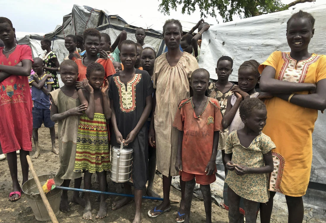 Angelina Wicyote, a 39-year-old mother of eight and resident of the camp, center, stands with her family during a visit of UNCHR High Commissioner Filippo Grandi to South Sudan's largest camp for the internally-displaced, in Bentiu, South Sudan Sunday, June 18, 2017. Thousands of South Sudanese now live in U.N. protected camps, including eighty percent of Bentiu's population. (AP)