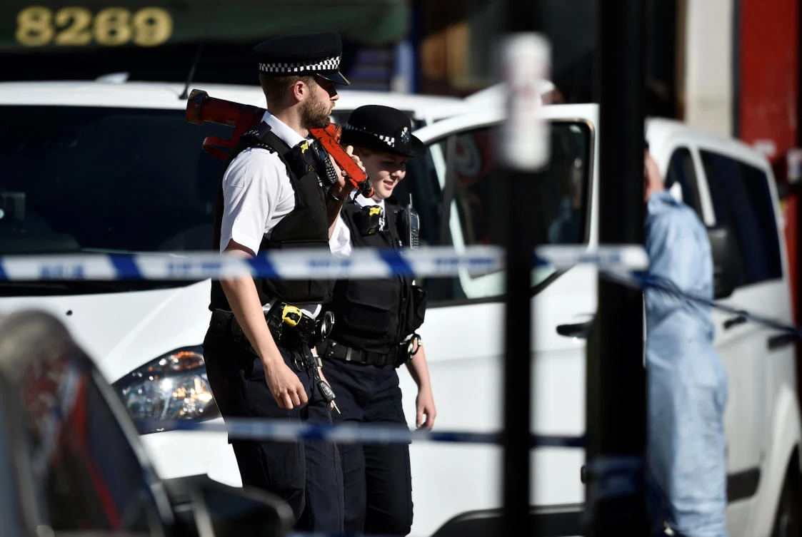 Police officers walk behind cordon tape at the scene of an attack where a man drove a van at Muslim worshippers outside a mosque in Finsbury Park in North London, Britain, June 19, 2017. (Photo: Reuters/Hannah McKay)