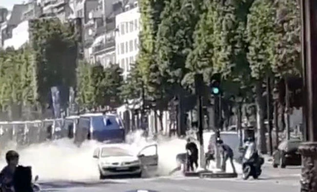 French police officers engage with a suspect outside a car at the Champs Elysees avenue in Paris on Mondayv in this still image obtained from social media. (Eugenio Morcillo via Reuters)