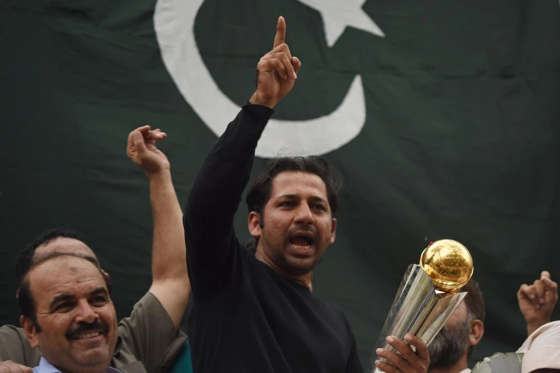 Pakistani cricket captain Sarfaraz Ahmed acknowledges fans as he holds the Champions Trophy following his arrival in Karachi from London on Tuesday, after Pakistan's win in the International Cricket Championship (ICC) Champions Trophy final against India. (AFP)