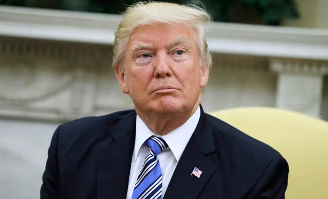 President Donald Trump is seen in the Oval Office of the White House in Washington on Monday. A new poll by The Associated Press-NORC Center for Public Affairs Research finds that most Americans say the federal courts were acting properly when they blocked President Donald Trump's travel ban from going into effect. (AP Photo/Evan Vucci)