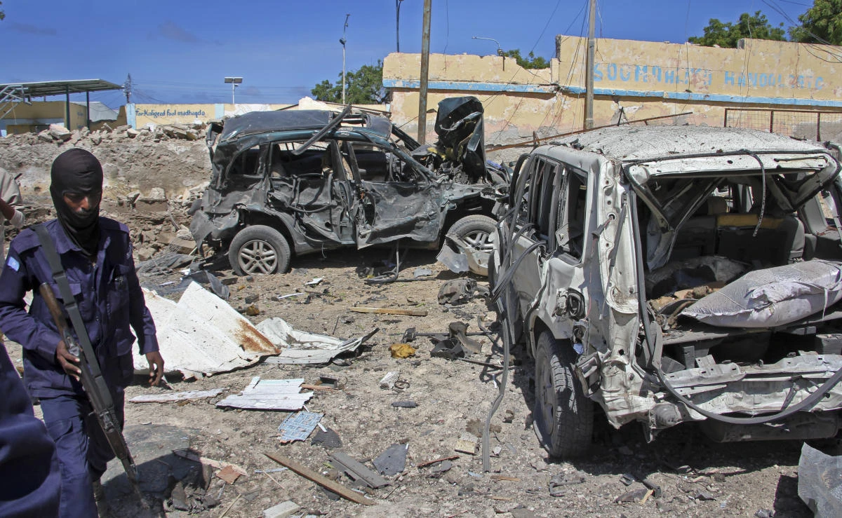 A Somali soldier walks past destroyed vehicles at the scene of a car bomb attack in Mogadishu on Tuesday. (AP)