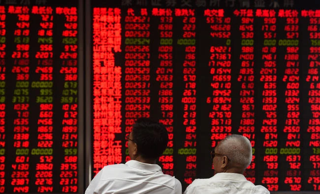 This file photo taken on June 15, 2016 shows investors monitoring stock price movements at a securities company in Beijing. Chinese shares will be included for the first time in a leading US-based index of emerging market shares, New York-based MSCI announced on Tuesday. (AFP / GREG BAKER)