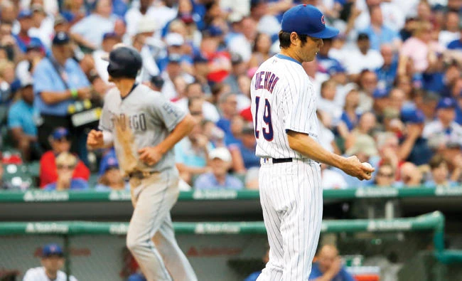 Chicago Cubs relief pitcher Koji Uehara, right, heads back to the mound after giving up a bases-loaded walk to San Diego Padres' Luis Torrens, scoring Wil Myers, background left, during the eighth inning of a baseball game Wednesday in Chicago. (AP)