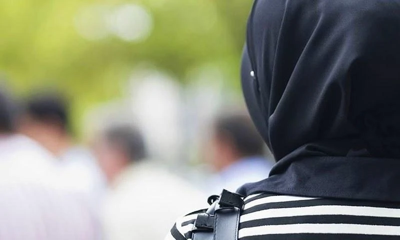 The woman claims that her manager even brought in colored hijabs for her to wear instead of her black headscarf. (File photo: AFP)