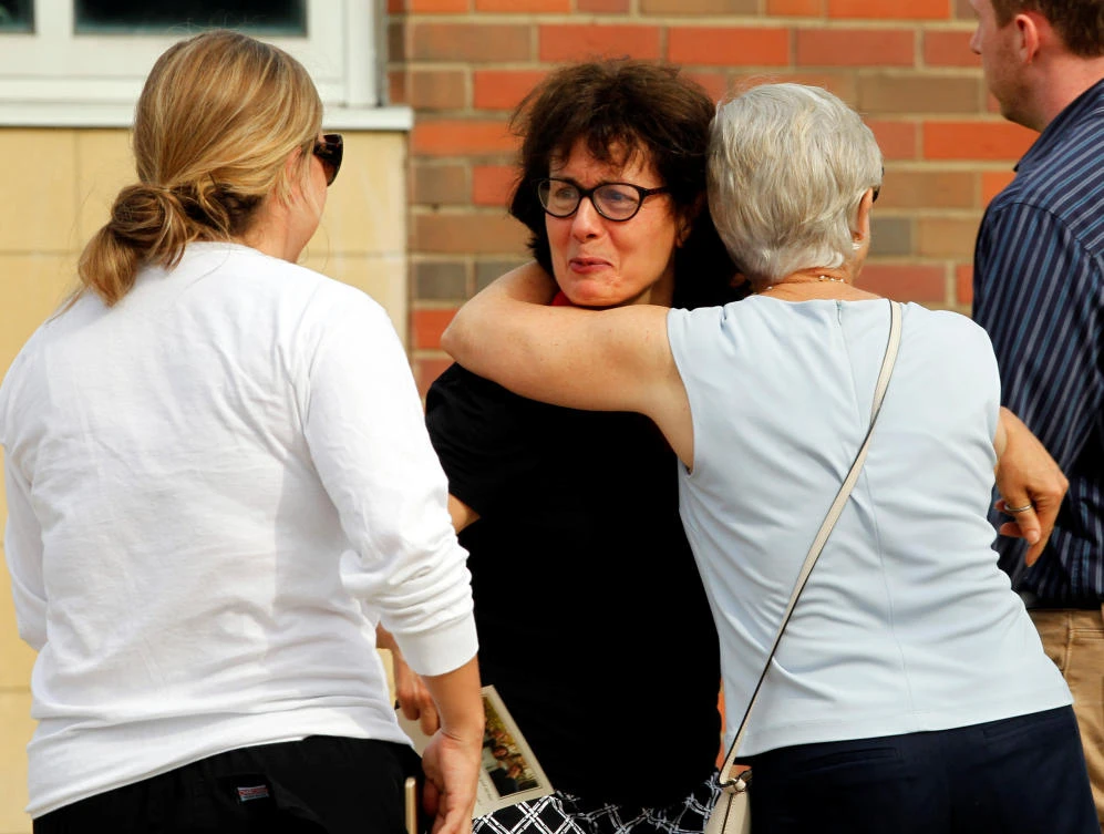 Mourners console one another over the death of Otto Wambire, who died after his release from North Korea, in Wyoming, Ohio, on Thursday. (Reuters)