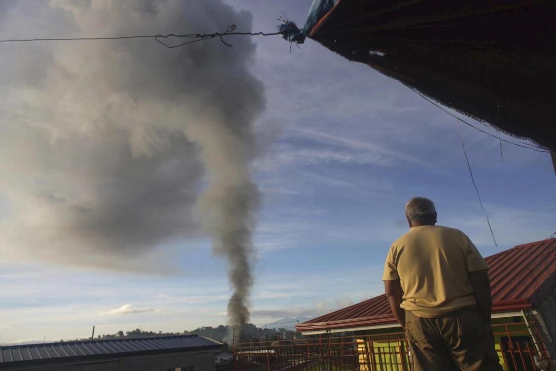 A resident looks at a burning structure during clashes between Filipino troops and militants in Marawi city on Friday. (AP)