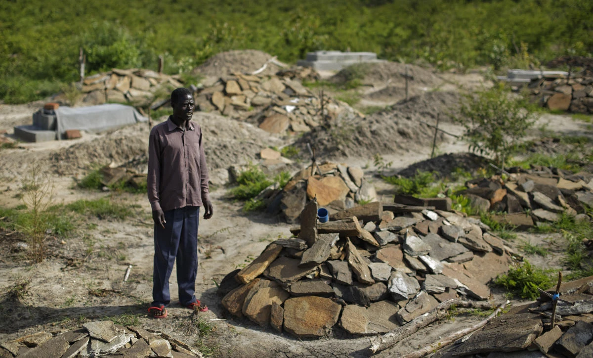 South Sudanese refugee James Malish, whose mother and sister recently died days apart, visits their graves and stands by that of his sister Lucia Tokosa, on an isolated patch of land designated by Ugandan officials on the edge of Bidi Bidi, the world's largest refugee settlement, in northern Uganda, in this photo taken earlier this month.(AP)