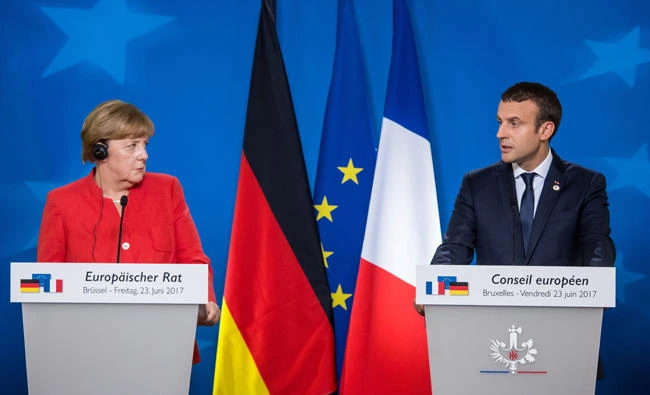 German Chancellor Angela Merkel (L) and French President Emmanuel Macron (R) give a press conference following the European Union leaders summit at the European Council in Brussels on Friday. The EU has said it will restrict visas for countries who refuse to take back migrants who have no right of asylum in Europe. (AFP / Aurore Belot)