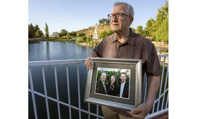 Frank Kerrigan holds onto a photograph of his three children John, Carole, and Frank, near Wildomar, California. Kerrigan, who thought his son Frank had died, learned he buried the wrong man. (Andrew Foulk/The Orange County Register via AP)
