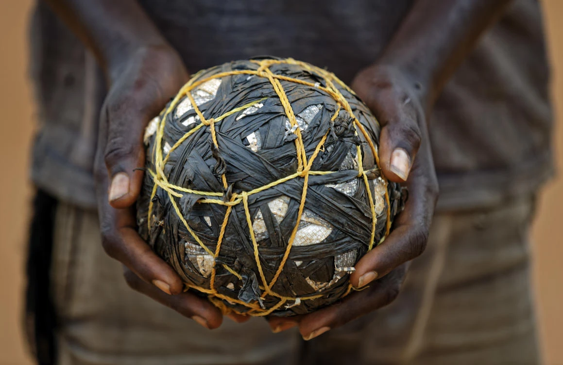 In this photo taken Saturday, June 3, 2017, a South Sudanese refugee boy holds a makeshift ball as he plays with his friends in the Bidi Bidi refugee settlement in northern Uganda. Soccer fields and inter-village competitions are found across the world's largest refugee settlement and even more are being created, underscoring the importance of sport in a community trying to forget the horrors of war with a rare source of entertainment in an otherwise dreary existence. (AP)