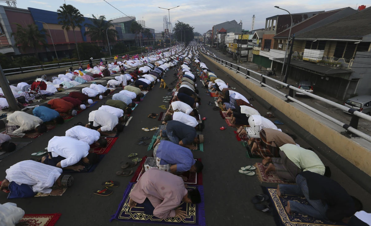 Muslim perform an Eid al-Fitr prayer to mark the end of the holy fasting month of Ramadan on a street in Jakarta, Indonesia, Sunday, June 25, 2017. (AP)