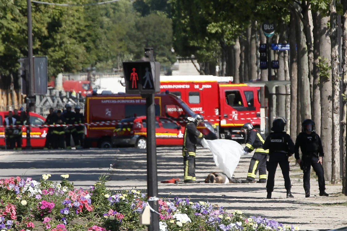 FILE - In this June 19 2017 file photo, rescue workers cover the dead body of an attacker on the Champs Elysees in Paris. The jihadis' targets are depressingly repetitive: the Brussels metro (twice), Paris' Champs-Elysees (twice) and tourist-filled bridges in London (twice). And that's just the past few months. (AP)